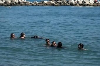 Ayancık sahilinde serinlemek için denize giren iki kız çocuğu, dalgalara